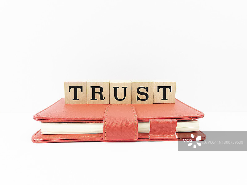 红色日记本上的“信任”字样图片素材