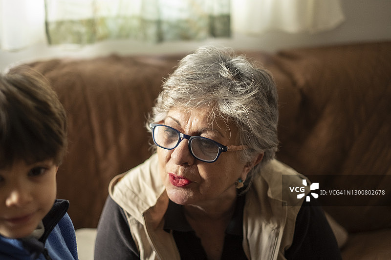 自然光下的家庭温馨一幕：奶奶安慰孙子图片素材