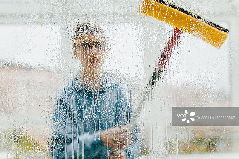 年轻男人在家擦窗户图片素材
