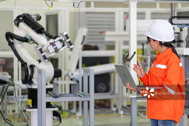 工程师在智能工厂设置自动机器人手臂图片素材