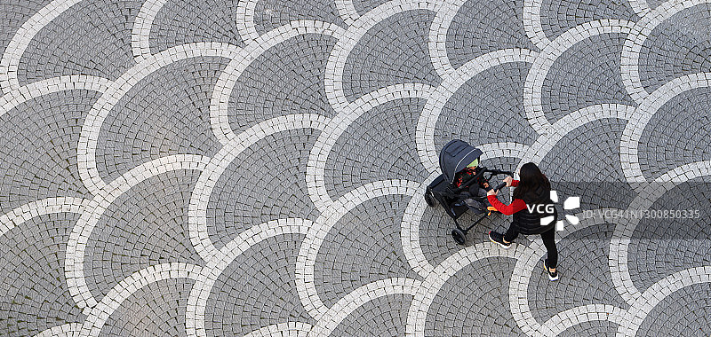 母亲戴口罩用婴儿车推着宝宝图片素材