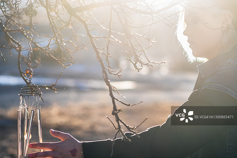 伸出手触摸风铃的少女图片素材