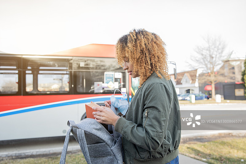 在校园附近等公共交通工具去上大学课程的年轻黑人女大学生图片素材
