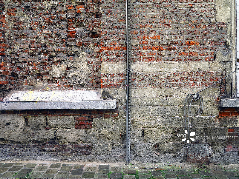 老旧的砖石墙、电缆和人行道图片素材
