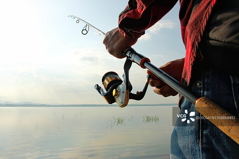 渔民在湖中用钓竿钓鱼图片素材