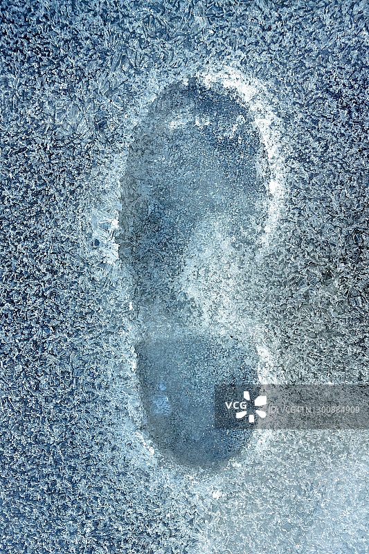 冰冻水坑中的鞋印图片素材