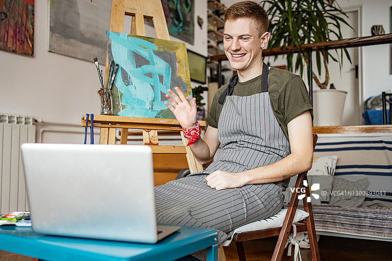年轻艺术家在视频通话中展示他的作品图片素材