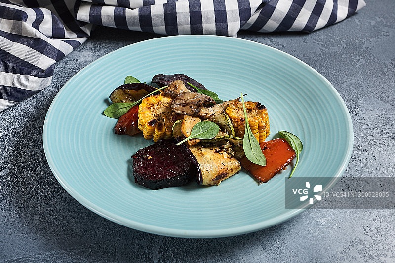 蓝色盘子里的烤蔬菜图片素材