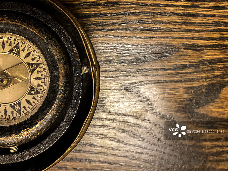 深色木质背景上的古董指南针局部图片素材