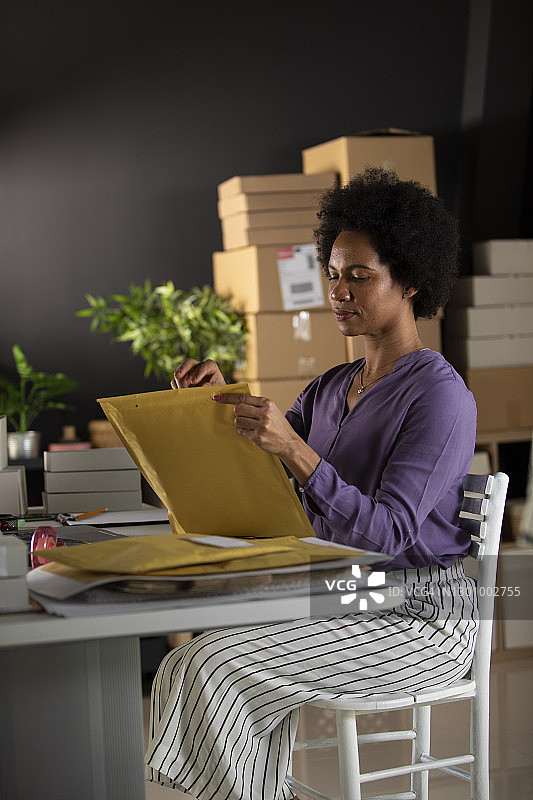 中年女企业家将客户订单装入信封图片素材