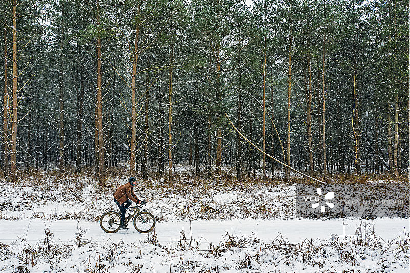 雪地森林赛道上的骑行者侧面像图片素材