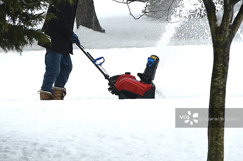 男人在宾夕法尼亚州的暴风雪后使用扬雪机图片素材