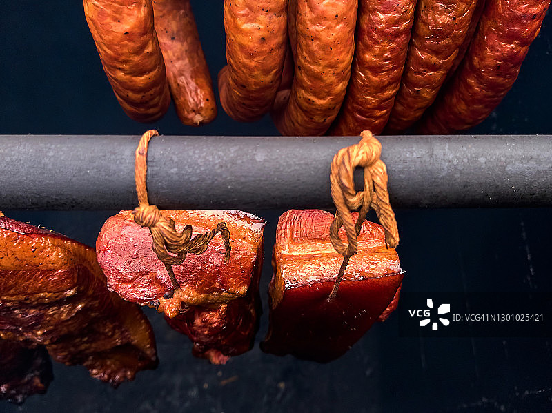 烟熏房中挂在架子上的培根和香肠图片素材