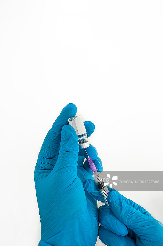 戴蓝色医用手套的手拿着疫苗图片素材