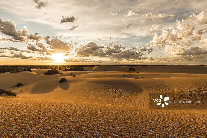 日落时分壮丽天空下的干旱沙漠沙丘环境图片素材