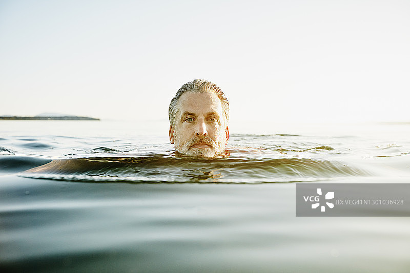 夏日傍晚海湾中游泳中年男人肖像图片素材