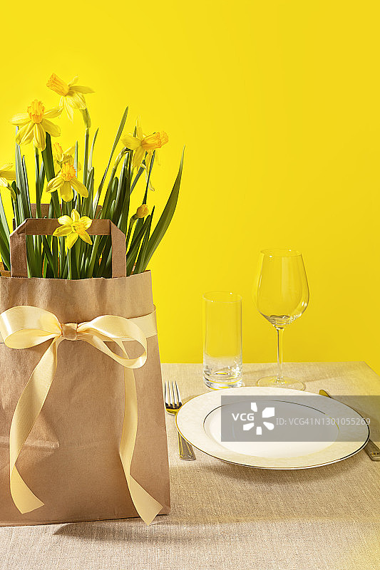 明亮背景纸袋里的春季黄色水仙花图片素材