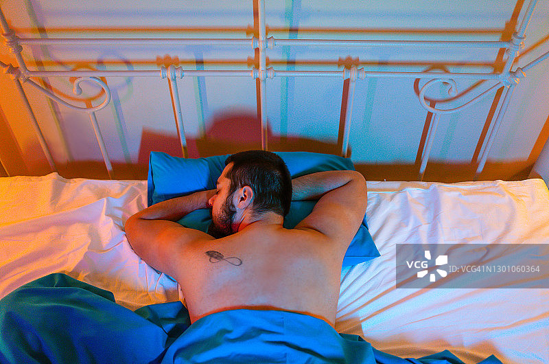 男人在家里的床上睡觉图片素材