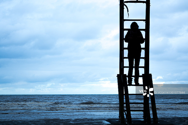沙滩台阶上的剪影女人图片素材