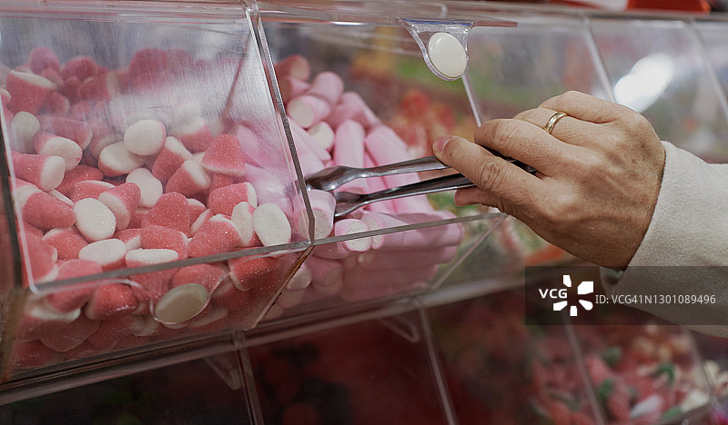 从柜台拿软糖的人图片素材