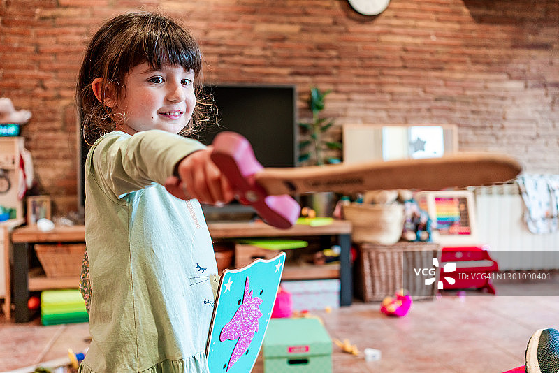 4岁小女孩用剑和盾牌玩战斗游戏图片素材