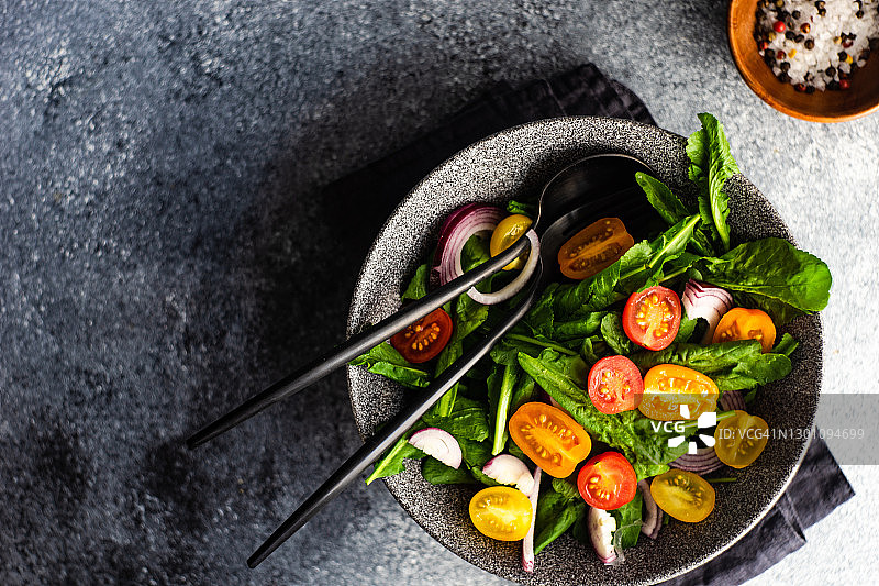 新鲜芝麻菜沙拉碗，配樱桃番茄和红洋葱图片素材