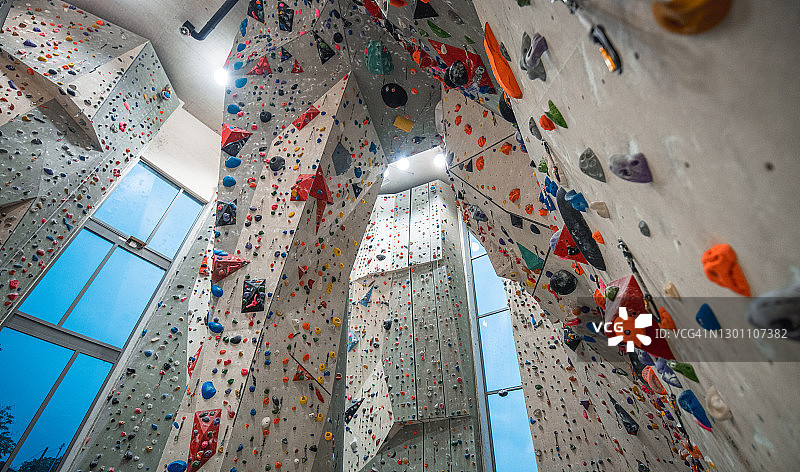 攀岩馆内固定在垂直墙壁上的彩色岩点图片素材