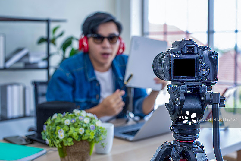 男性博主用摄像机拍摄视频。社交媒体，网红，新技术和互联网概念图片素材