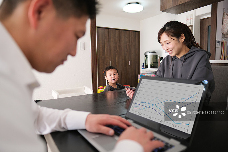 父母在家工作，孩子在旁边图片素材