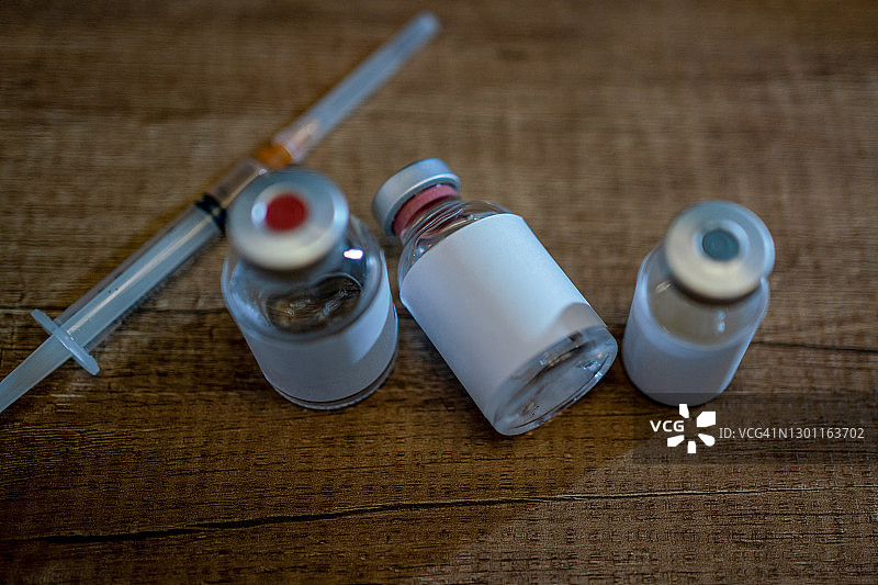 冠状病毒或COVID-19疫苗，配有注射器、防护手套和口罩，准备用于接种疫苗图片素材