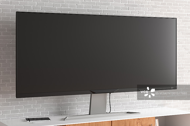 客厅白色砖墙旁的电视柜上的宽屏电视图片素材