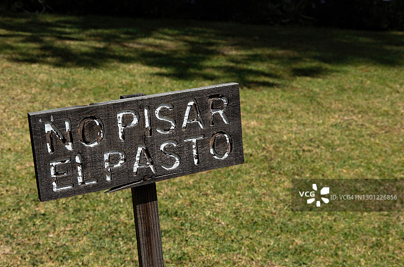 草坪上的西班牙语“请勿践踏草坪”标志图片素材