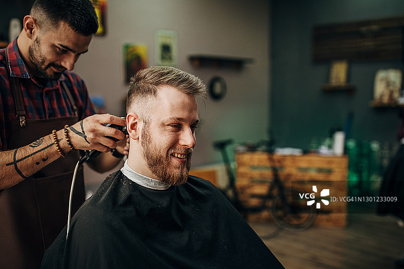 男发型师在理发店为顾客理发图片素材