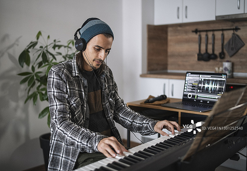 在家庭录音室工作的年轻男人图片素材