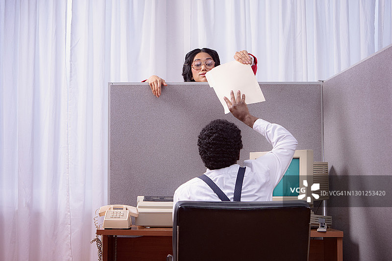 在隔间交换文件的复古办公室工作人员图片素材