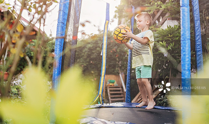 可爱小男孩跳跃玩足球图片素材