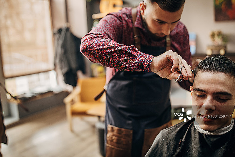 理发师用剪刀为顾客理发图片素材