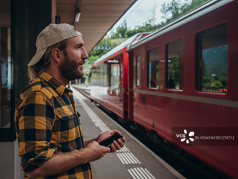 男子在火车站查看手机图片素材