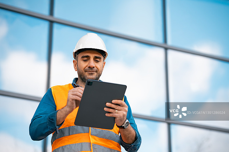 年轻男工程师戴着安全帽和背心图片素材