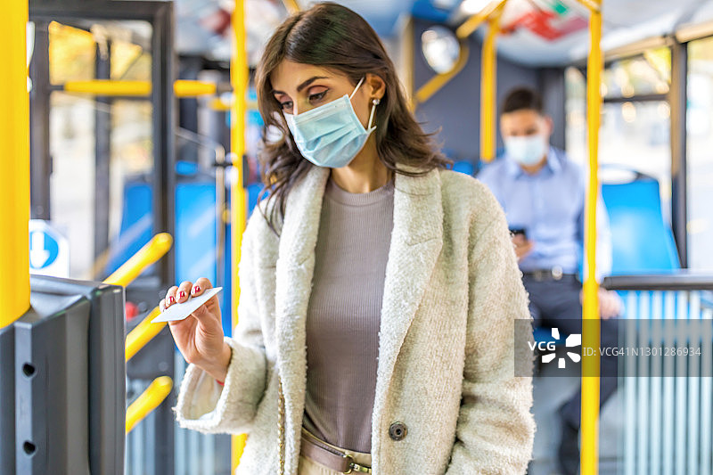 中年妇女在有轨电车或公共汽车上验证车票图片素材