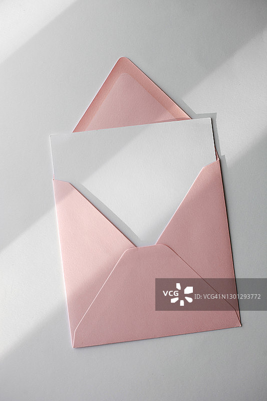粉色信封和白色空白卡片，白色背景，阳光和时尚阴影图片素材