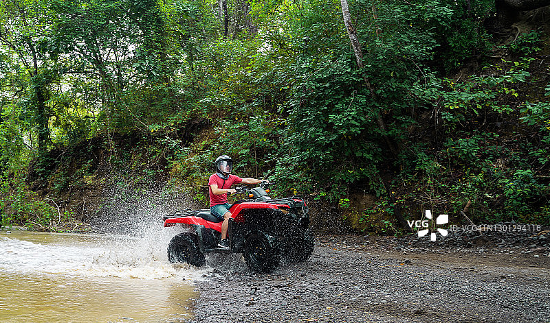 青少年男孩驾驶四驱车在哥斯达黎加过河图片素材
