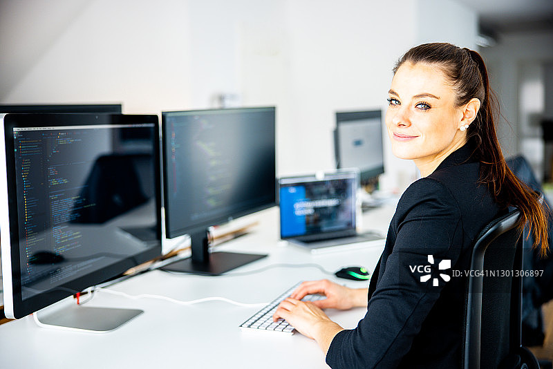 在办公室使用台式电脑的快乐女人图片素材