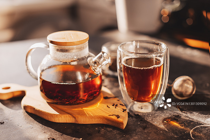 茶冲泡流程：茶道，一杯新鲜的红茶，温暖柔和的光线，深色背景图片素材