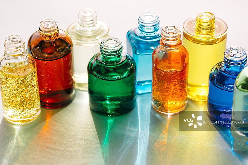 聚谷氨酸或面部精华液瓶子，具有美丽阴影和未来主义灰色背景上的照明反射图片素材