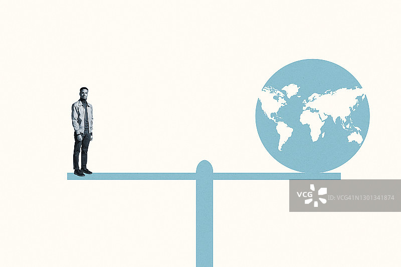 男子站在跷跷板上，跷跷板上放着蓝色地球图片素材
