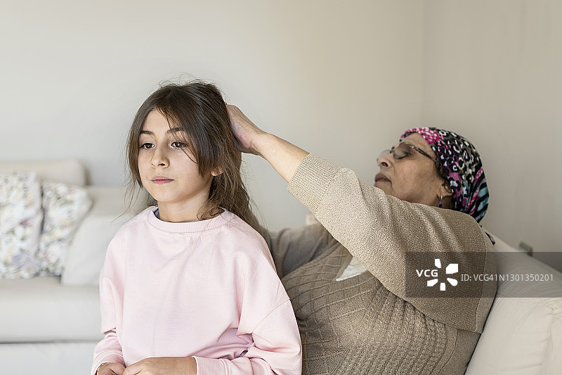 奶奶整理可爱小女孩的头发图片素材