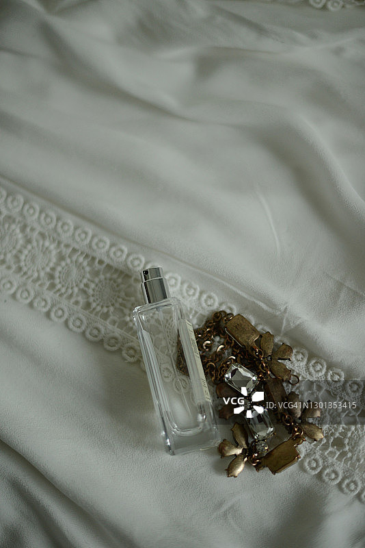 白色衬衫上的简单透明喷雾瓶和项链图片素材
