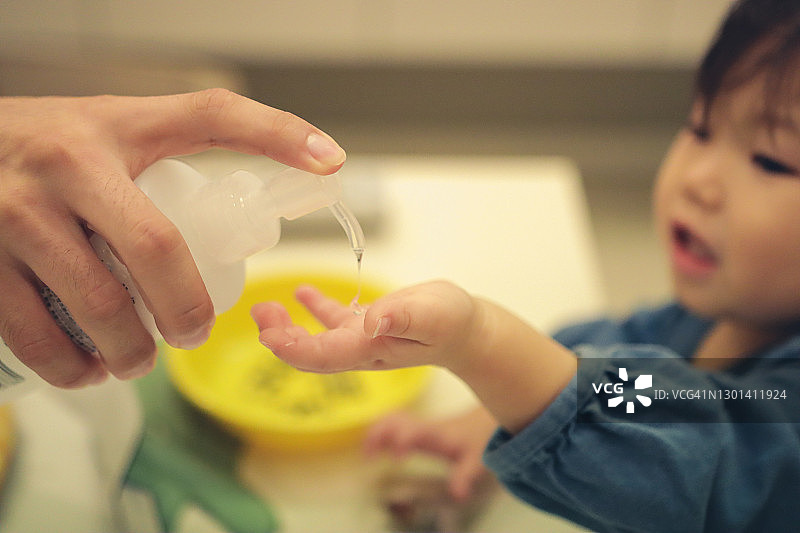 正在消毒双手的亚洲小女孩肖像图片素材