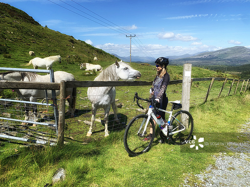 与小马合影的斯诺多尼亚国家公园女性自行车手图片素材